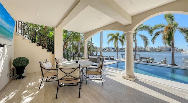 view of patio / terrace featuring a water view and a dock