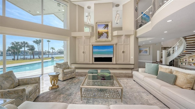 living room featuring a towering ceiling and a water view