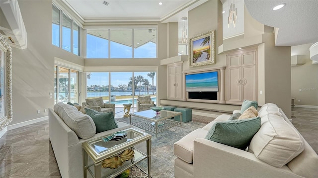 living room featuring a towering ceiling and ornamental molding