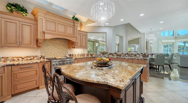 kitchen with light stone countertops, a center island, high end stove, and decorative light fixtures