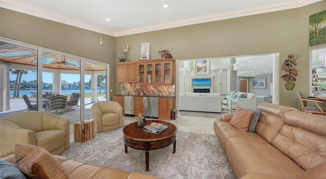 living room with ornamental molding, ceiling fan, and a water view