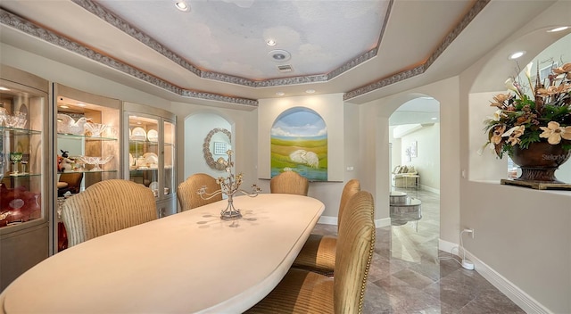 dining area with a raised ceiling