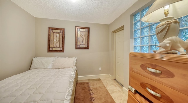 tiled bedroom featuring a textured ceiling