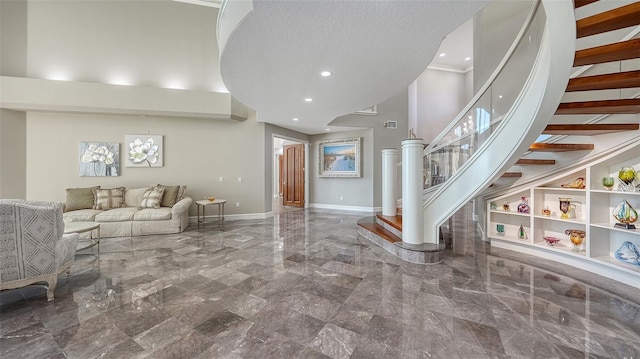 living room with a towering ceiling, a textured ceiling, and built in features