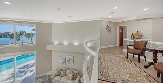 living room with ornamental molding, light hardwood / wood-style floors, and a water view