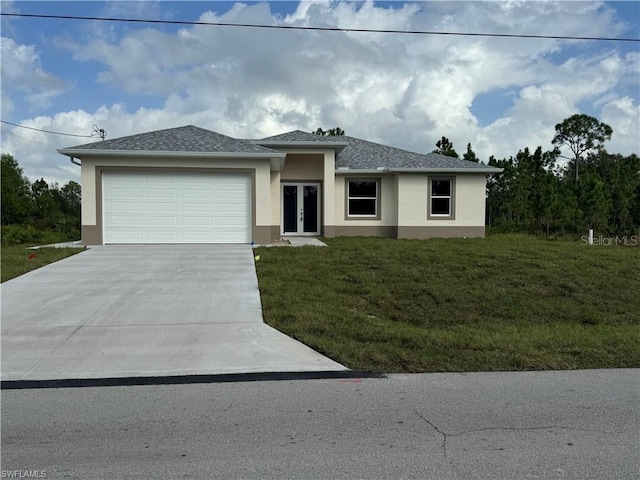 view of front of home with french doors, a front yard, and a garage