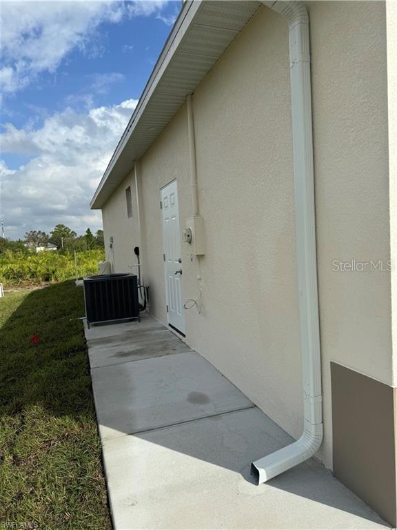 view of side of home featuring a patio and central AC unit