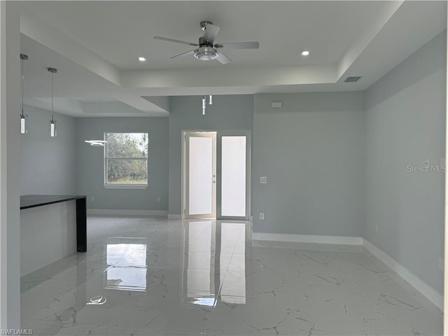 empty room with french doors, ceiling fan, and a tray ceiling