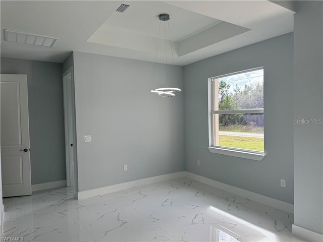 unfurnished room with a raised ceiling