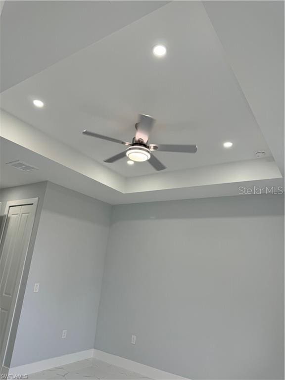 details with ceiling fan and a tray ceiling