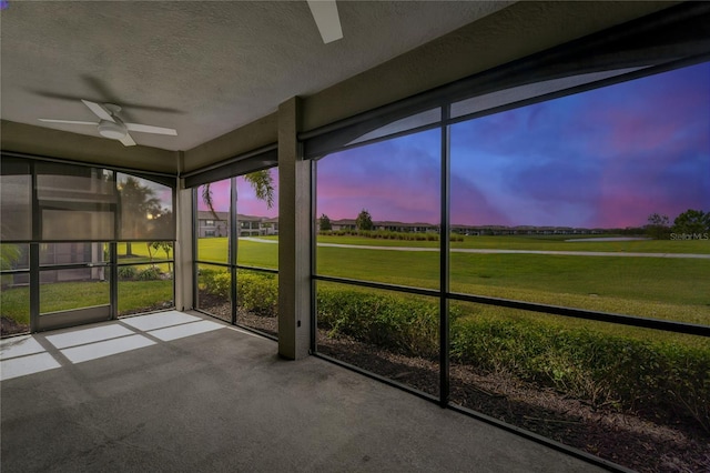 unfurnished sunroom featuring ceiling fan