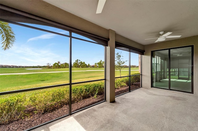 unfurnished sunroom with ceiling fan