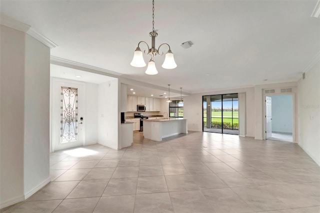 kitchen with stainless steel appliances, a kitchen island, pendant lighting, a notable chandelier, and white cabinetry