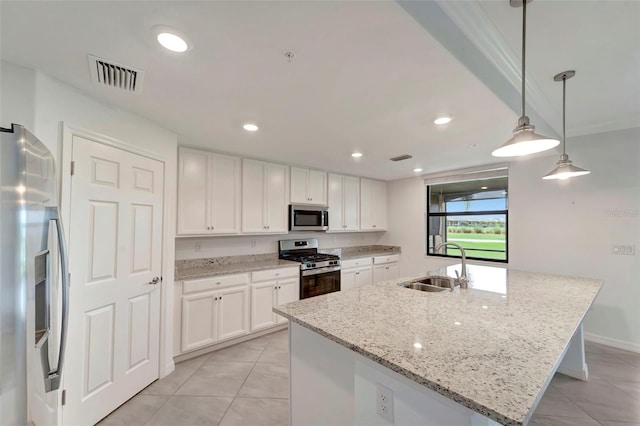 kitchen featuring light stone countertops, sink, hanging light fixtures, a kitchen island with sink, and appliances with stainless steel finishes