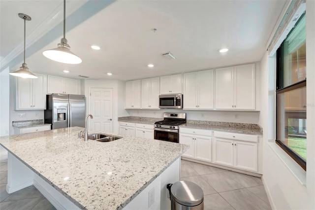 kitchen with a kitchen island with sink, white cabinets, hanging light fixtures, and appliances with stainless steel finishes