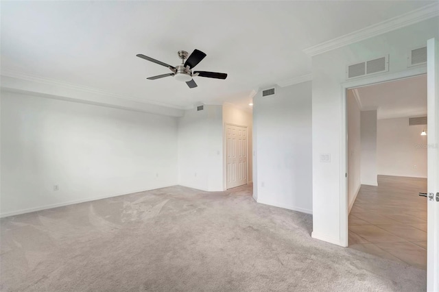 empty room featuring light carpet, crown molding, and ceiling fan