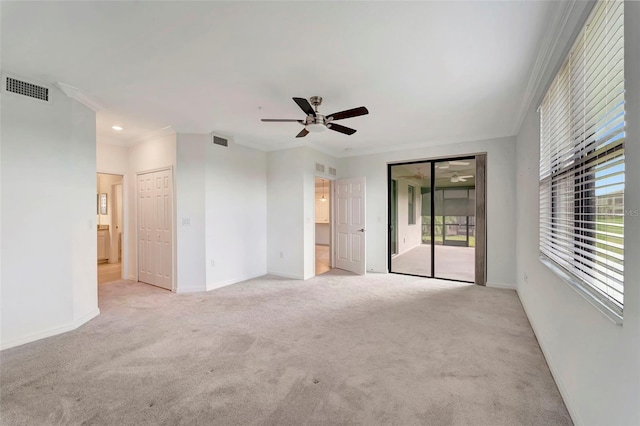 carpeted spare room featuring ceiling fan and crown molding