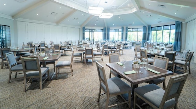 carpeted dining area with beam ceiling and high vaulted ceiling