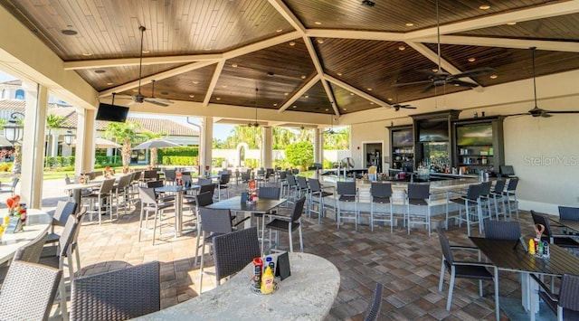 view of patio featuring a gazebo, ceiling fan, and exterior bar