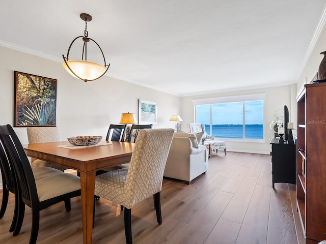 dining room with a healthy amount of sunlight, crown molding, and dark wood-type flooring