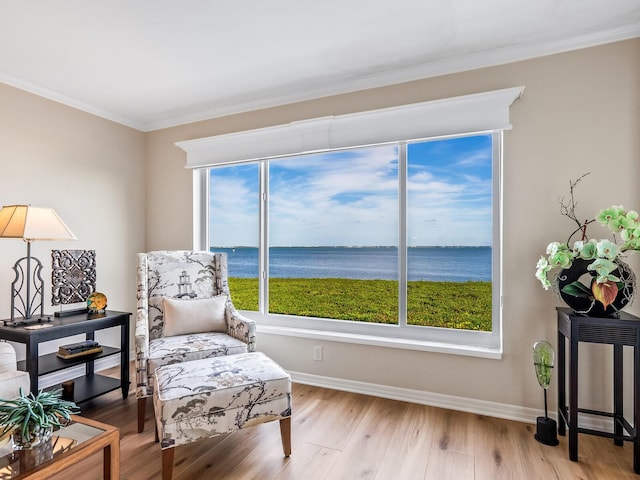 living area featuring ornamental molding, a water view, and light hardwood / wood-style floors