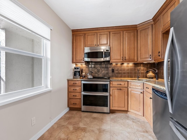 kitchen with a healthy amount of sunlight, decorative backsplash, and stainless steel appliances