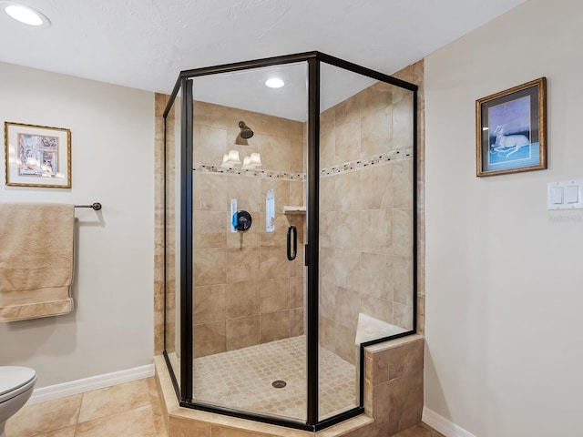 bathroom featuring tile patterned flooring, toilet, and a shower with door