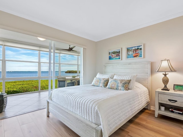 bedroom featuring a water view and light wood-type flooring