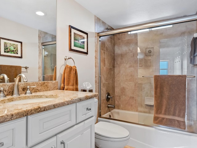 full bathroom featuring vanity, bath / shower combo with glass door, and toilet