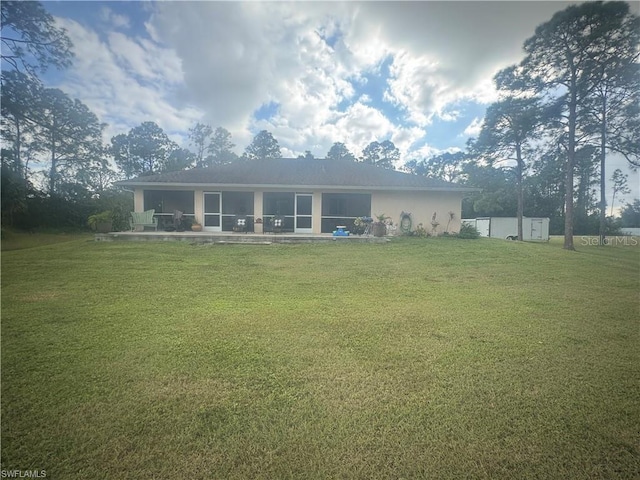 rear view of property with a yard