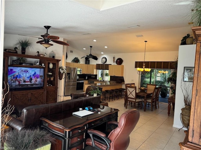 tiled living room with ceiling fan with notable chandelier, a textured ceiling, and vaulted ceiling