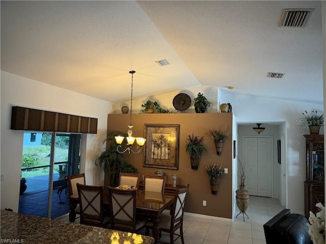 tiled dining space featuring lofted ceiling and a chandelier