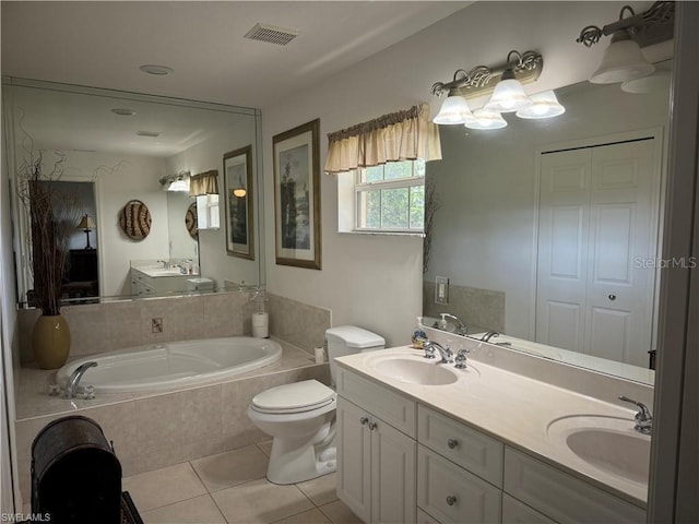 bathroom featuring tile patterned flooring, tiled bath, vanity, and toilet