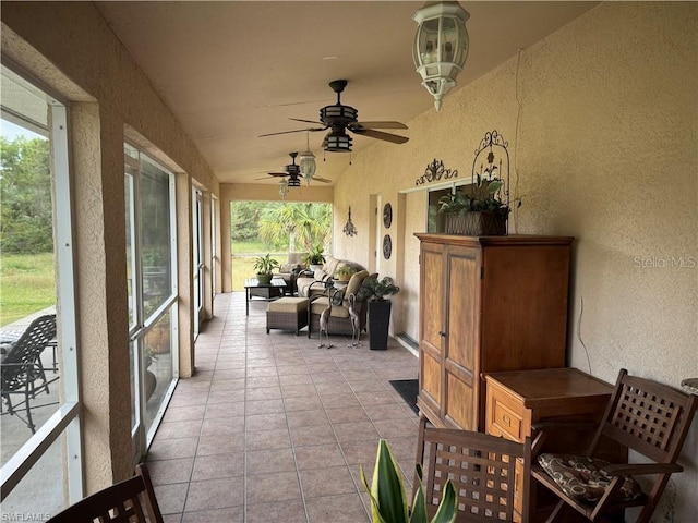 sunroom / solarium with ceiling fan and a healthy amount of sunlight