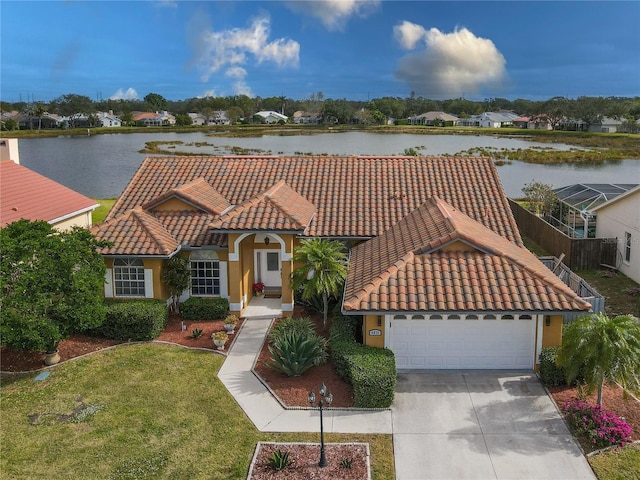 view of front of property featuring a front yard, a water view, and a garage