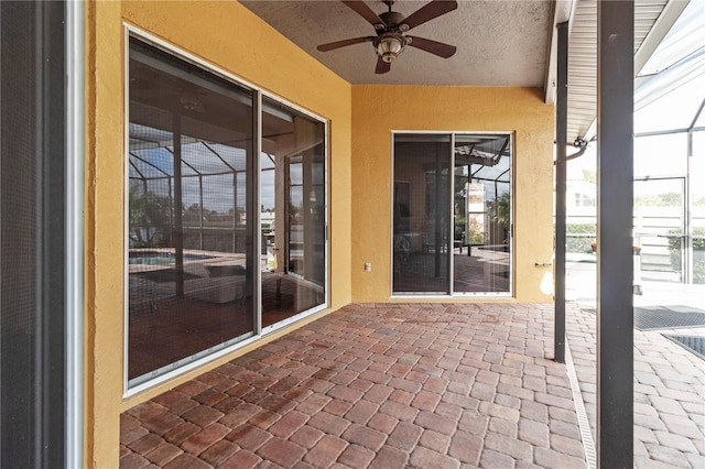 unfurnished sunroom featuring ceiling fan