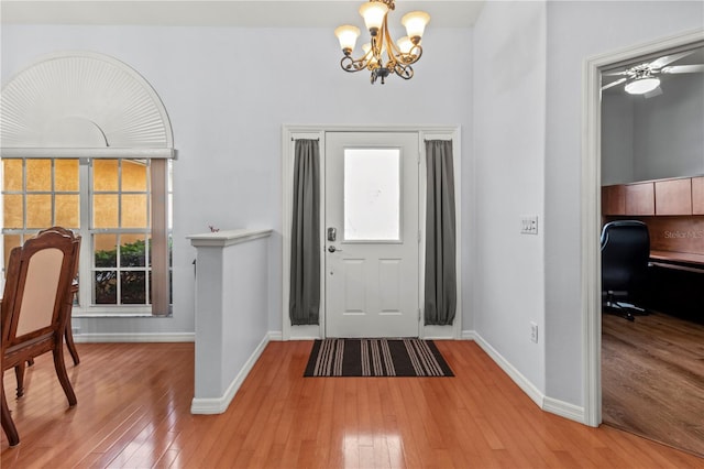 entryway featuring ceiling fan with notable chandelier and light hardwood / wood-style floors