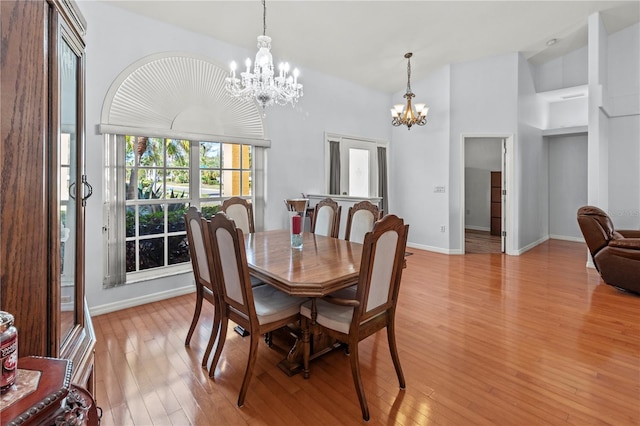 dining space with light hardwood / wood-style flooring and a chandelier