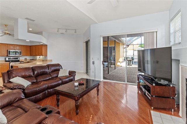 living room featuring ceiling fan and light wood-type flooring