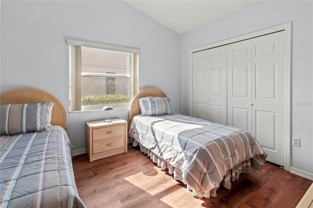 bedroom with light hardwood / wood-style floors, vaulted ceiling, and a closet