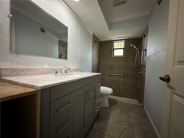 bathroom featuring vanity, tile patterned flooring, toilet, and tiled shower