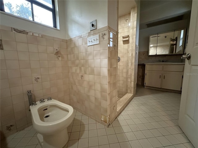 bathroom with a bidet, tile walls, tile patterned flooring, vanity, and walk in shower