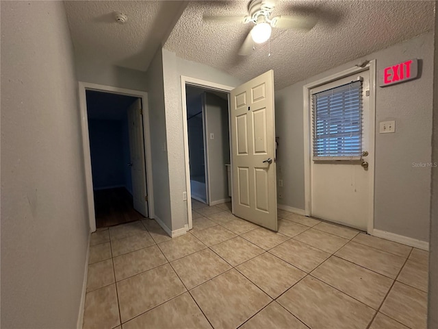 unfurnished bedroom featuring light tile patterned flooring, a textured ceiling, and ceiling fan