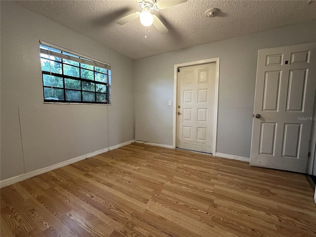 empty room featuring ceiling fan, hardwood / wood-style floors, and a textured ceiling