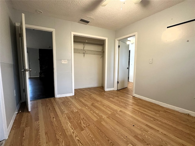 unfurnished bedroom featuring a closet, a textured ceiling, ceiling fan, and light hardwood / wood-style floors