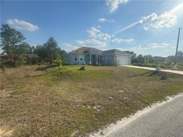 single story home featuring a garage and a front lawn