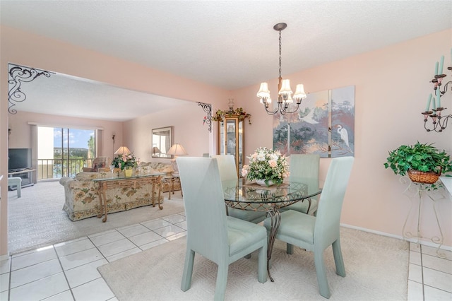 tiled dining room with an inviting chandelier