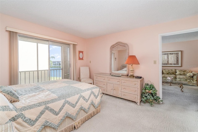 carpeted bedroom with access to exterior and a textured ceiling