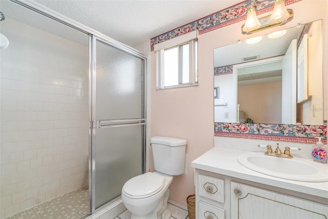 bathroom featuring a shower with door, vanity, a textured ceiling, and toilet