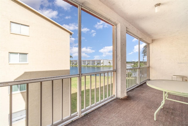 sunroom featuring a water view and a healthy amount of sunlight